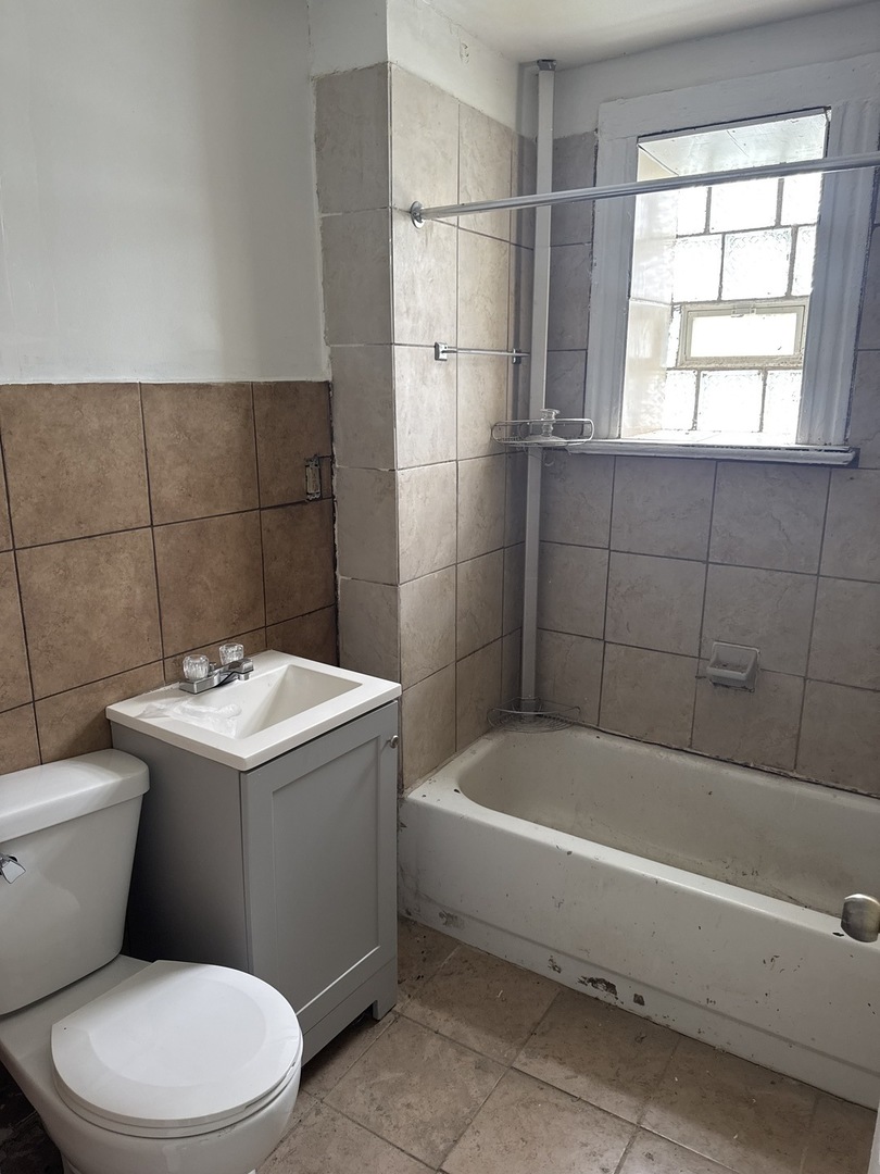1655 South Ridgeway Avenue Chicago, IL 60623 - Photo 7 of 19 a bathroom with a sink a toilet and bathtub