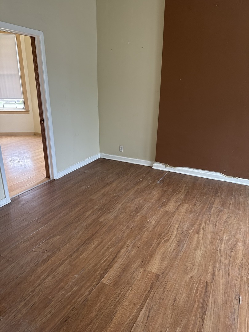 1655 South Ridgeway Avenue Chicago, IL 60623 - Photo 9 of 19 a view of an empty room with wooden floor and a window