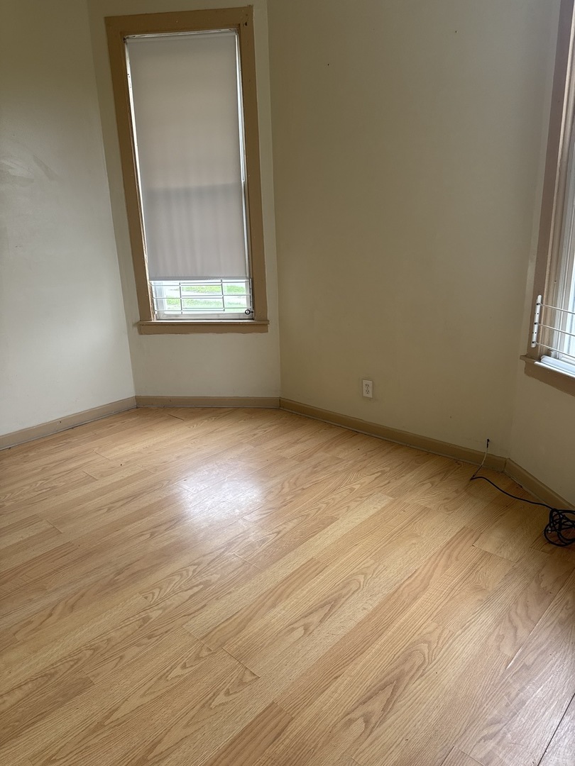 1655 South Ridgeway Avenue Chicago, IL 60623 - Photo 10 of 19 an empty room with wooden floor and a window