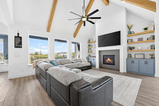 a living room with furniture a flat screen tv and a fireplace