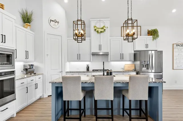 a kitchen with stainless steel appliances a table chairs and a refrigerator