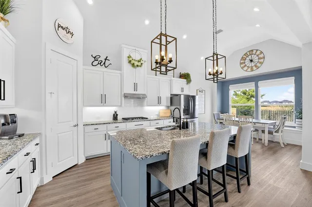 a open dining room with kitchen island stainless steel appliances furniture a large window and a view of kitchen