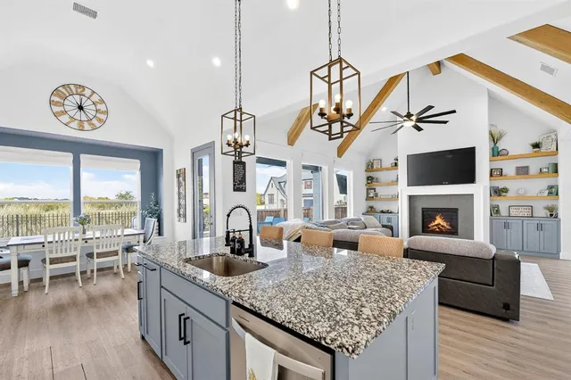 a kitchen with a table chairs refrigerator and a wooden floor
