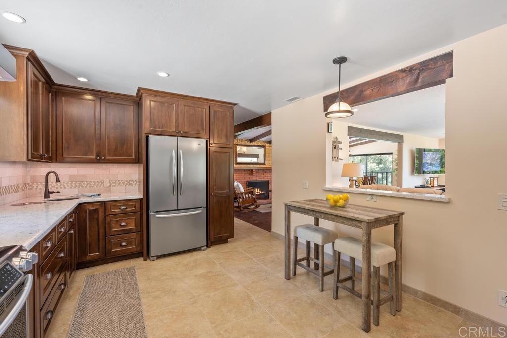 1057 Riverview Drive Fallbrook, CA 92028 - Photo 4 of 69 a kitchen with stainless steel appliances granite countertop a refrigerator a stove a sink a dining table and chairs with wooden floor