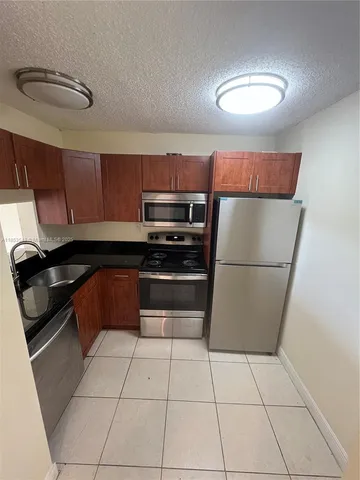 a kitchen with stainless steel appliances a refrigerator sink and microwave