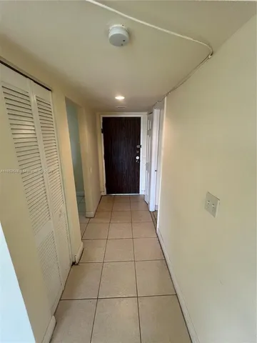 a view of hallway with a window and a refrigerator