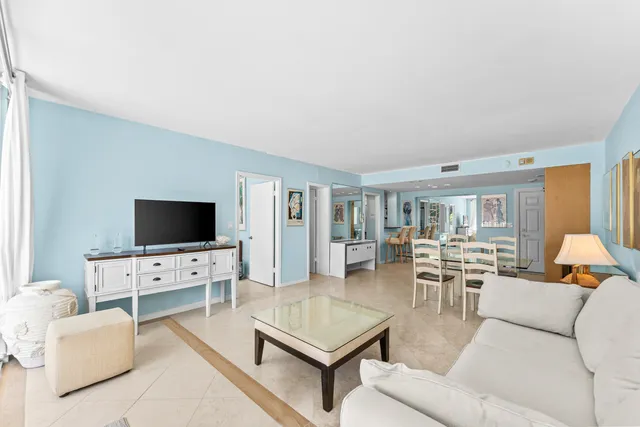 a living room with furniture a flat screen tv and a large window