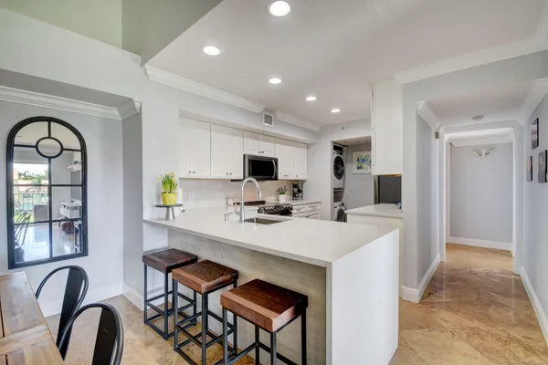 a kitchen with white cabinets and black appliances