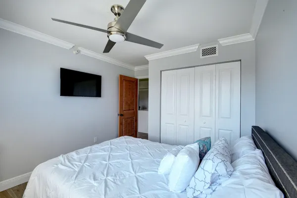 a bedroom with a bed and a flat tv screen on the dresser