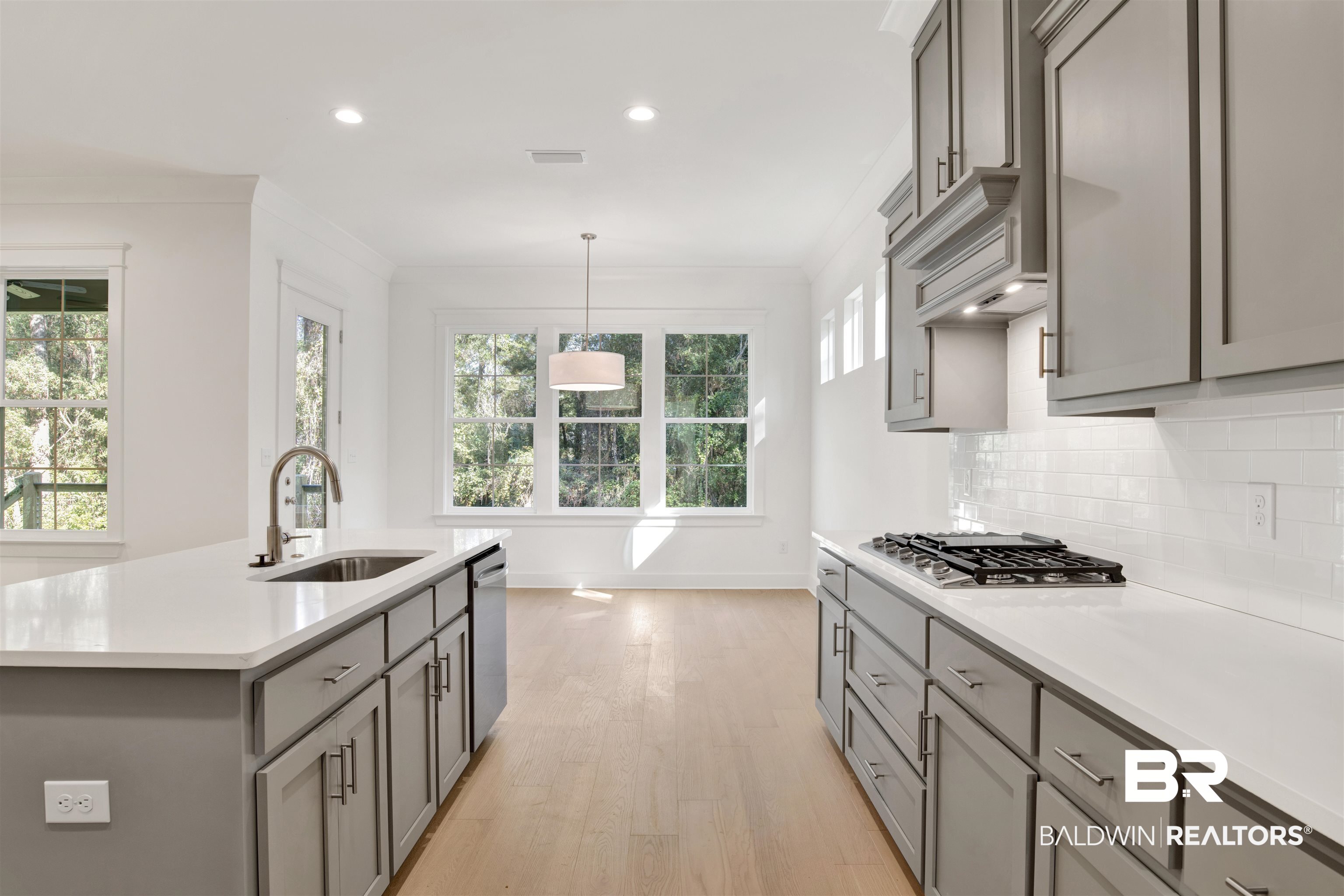 5 Long Leaf Circle Fairhope, AL 36532 - Photo 12 of 44 Kitchen featuring appliances with stainless steel finishes, a kitchen island with sink, a healthy amount of sunlight, and sink