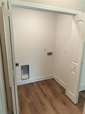 a view of a room with wooden floor and small window