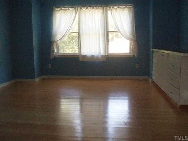 5600 Blacket Court Raleigh, NC 27604 - Photo 6 of 11 an empty room with wooden floor and windows