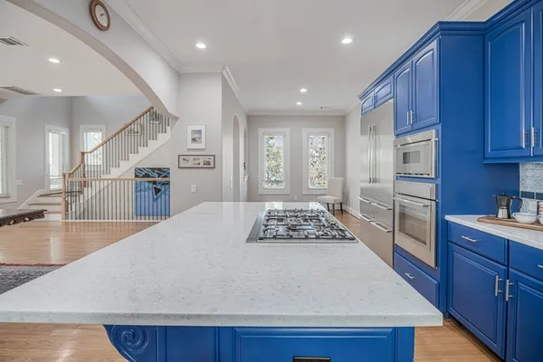 a large kitchen with granite countertop a large counter top stainless steel appliances and cabinets