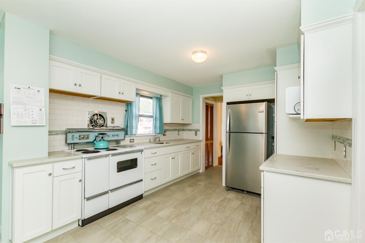19 Kings Road Netcong, NJ 07857 - Photo 8 of 24 a kitchen with a sink a refrigerator and white cabinets