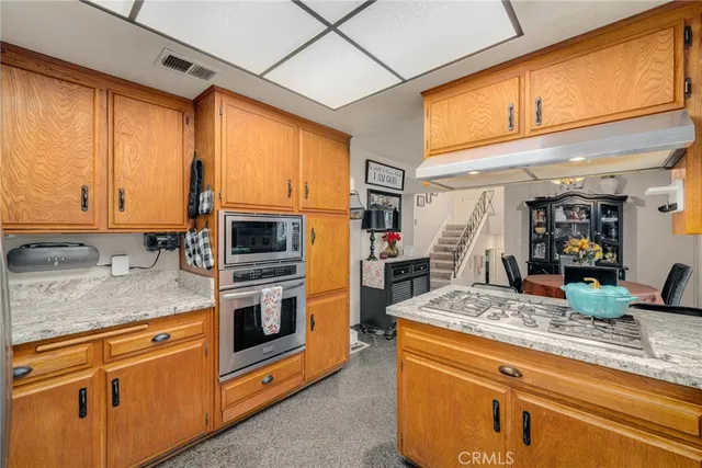 a kitchen with stainless steel appliances granite countertop a stove a sink and a microwave