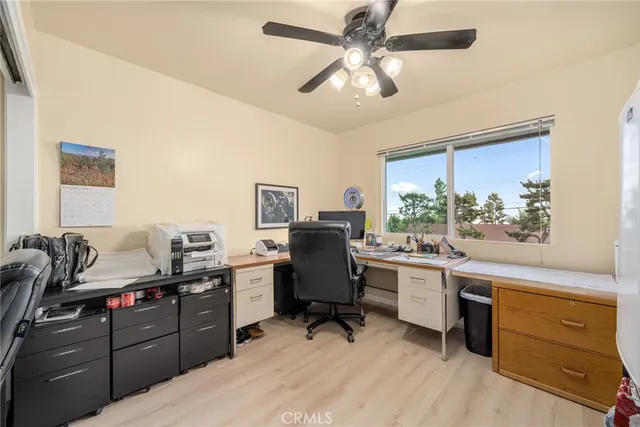 a view of a workspace with furniture and a window