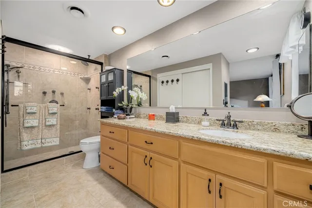 a spacious bathroom with a granite countertop sink mirror and shower