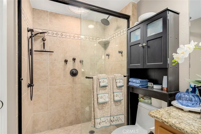 a bathroom with a granite countertop shower sink and mirror