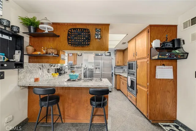 a kitchen with stainless steel appliances granite countertop a sink and a refrigerator