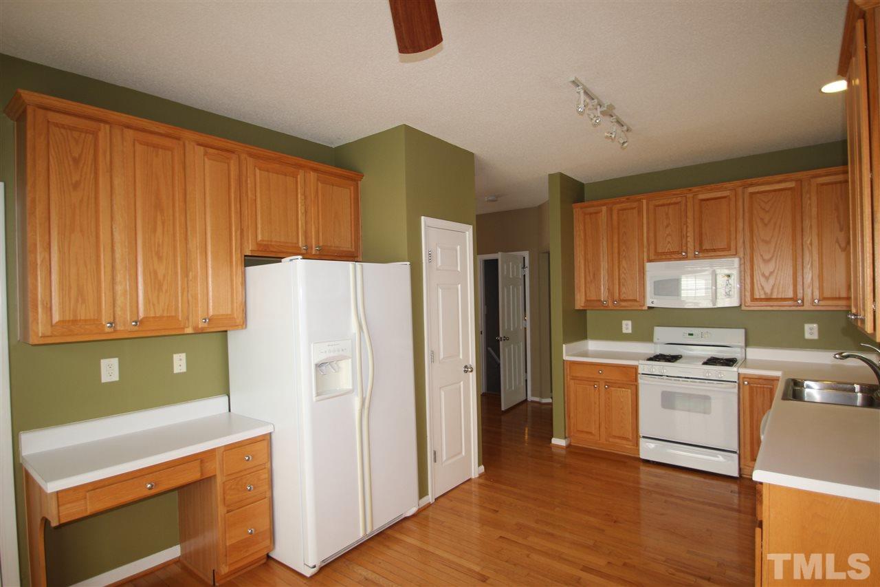 5312 Arete Way Raleigh, NC 27607 - Photo 5 of 20 a kitchen with stainless steel appliances granite countertop a refrigerator a stove top oven a sink and dishwasher with wooden floor