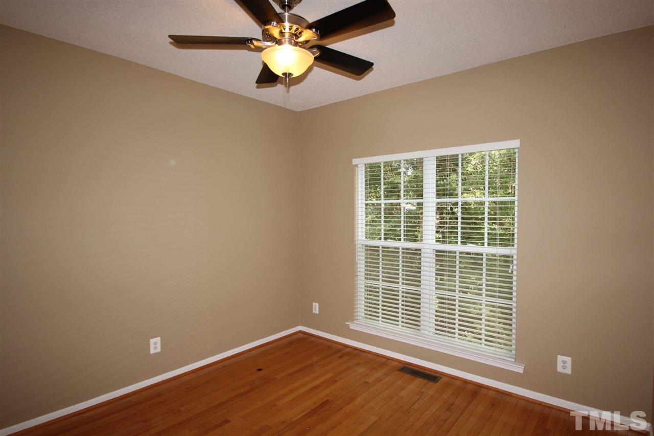 5312 Arete Way Raleigh, NC 27607 - Photo 6 of 20 a view of an empty room with a window and wooden floor