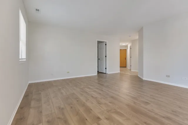 a view of an empty room and wooden floor