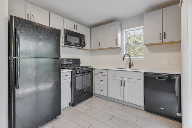 a kitchen with a refrigerator sink and cabinets