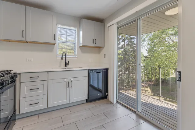 a kitchen with white cabinets and window