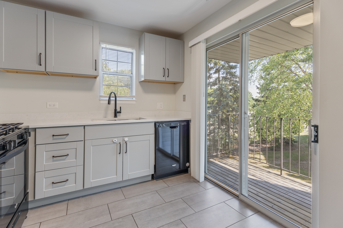 47 Gant Circle, Unit E Streamwood, IL 60107 - Photo 7 of 21 a kitchen with white cabinets and window