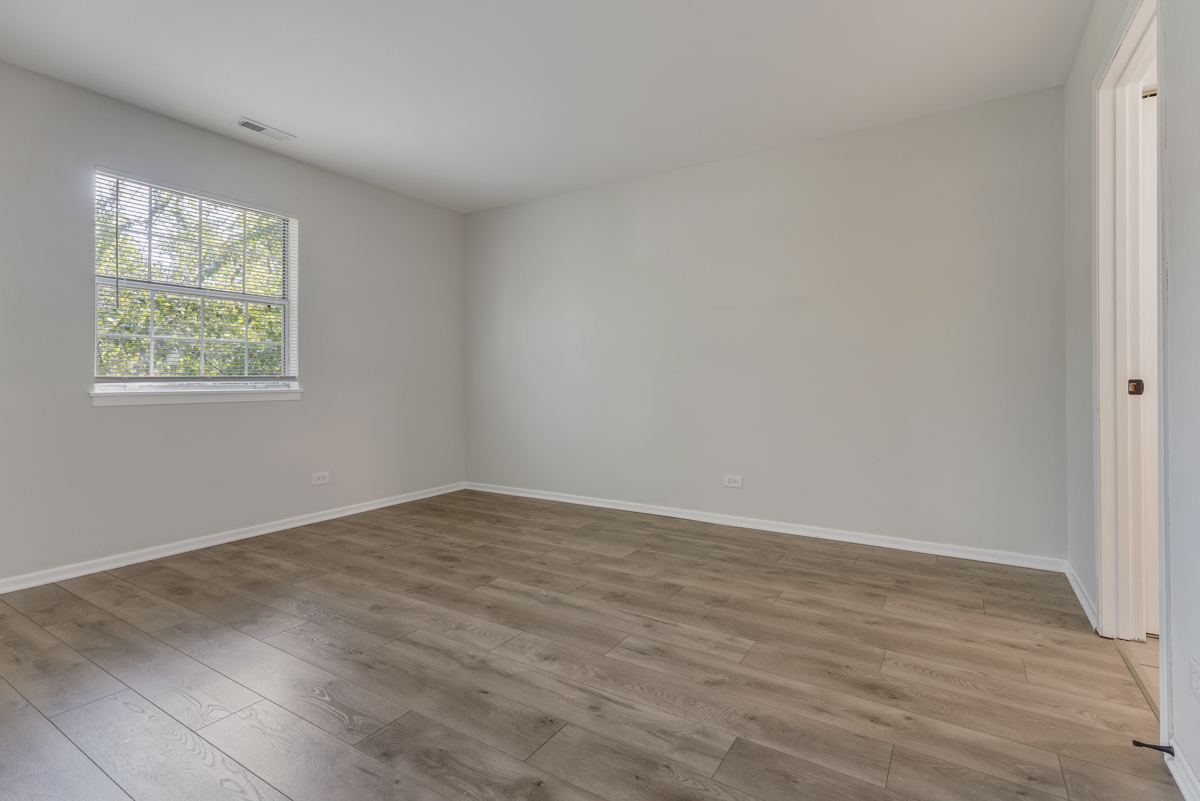 47 Gant Circle, Unit E Streamwood, IL 60107 - Photo 10 of 21 an empty room with wooden floor and windows