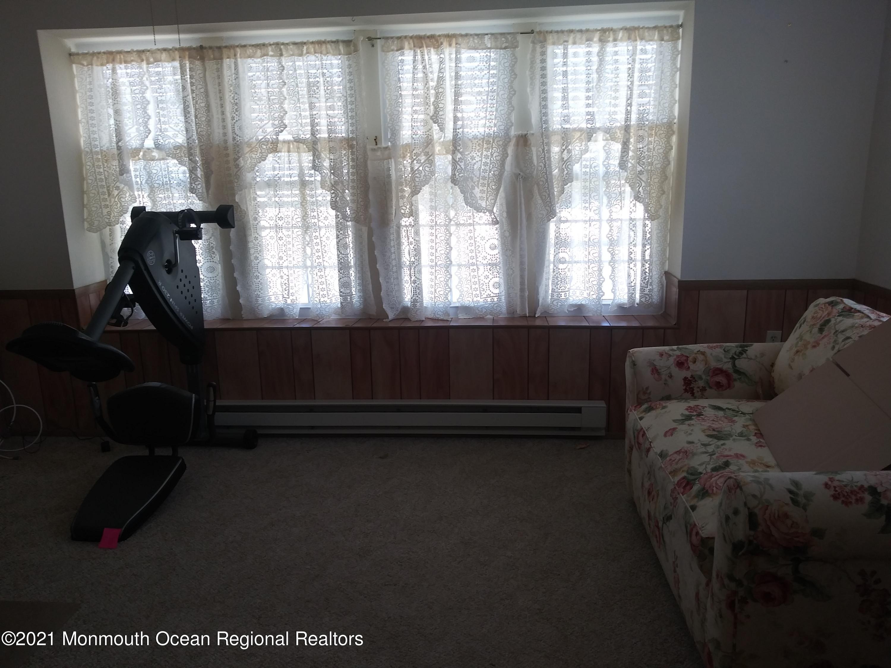 9 Ashley Road, Unit 63 Whiting, NJ 08759 - Photo 5 of 11 a living room with furniture and a floor to ceiling window