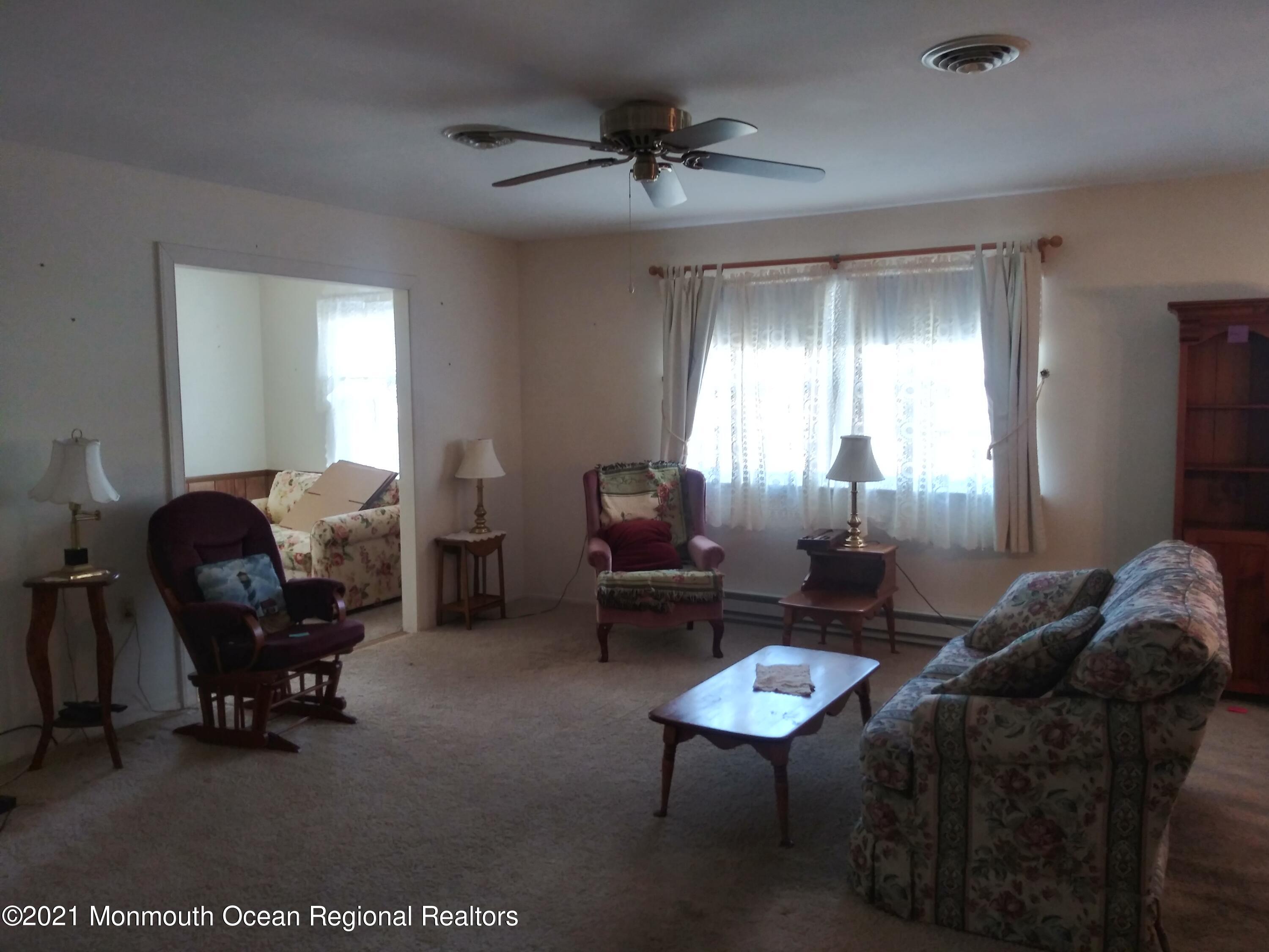 9 Ashley Road, Unit 63 Whiting, NJ 08759 - Photo 6 of 11 a living room with furniture and a chandelier