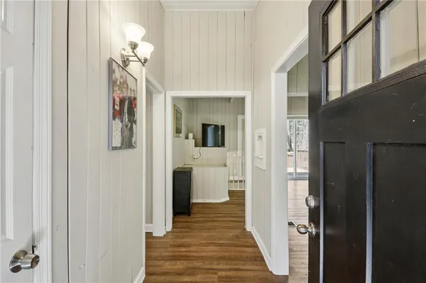 a view of a hallway with wooden floor and staircase
