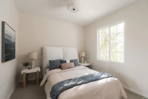 a bedroom with a bed and a flat tv screen on the dresser