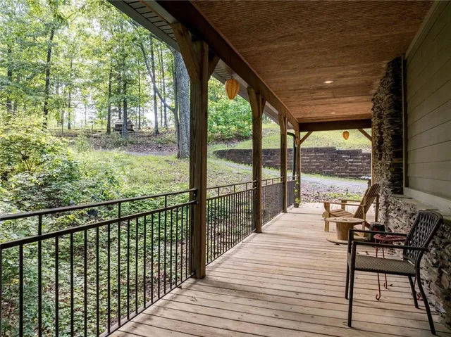 a balcony with wooden floor table and chairs