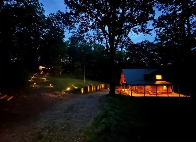 an aerial view of residential house with outdoor space and trees all around
