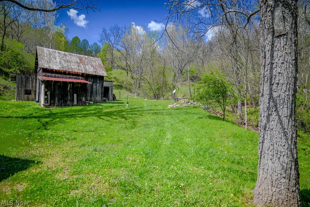 1547 Providence Road Elizabeth, WV 26143 - Photo 26 of 32 Expansive green space featuring a rustic barn structure with a corrugated metal roof and a lean-to addition