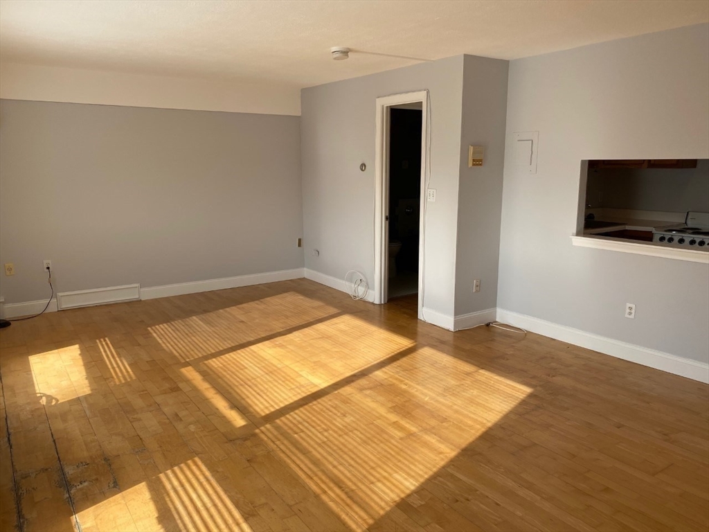 4 Trowbridge Place, Unit 3B Cambridge, MA 02138 - Photo 10 of 11 a view of a livingroom with wooden floor and a flat screen tv