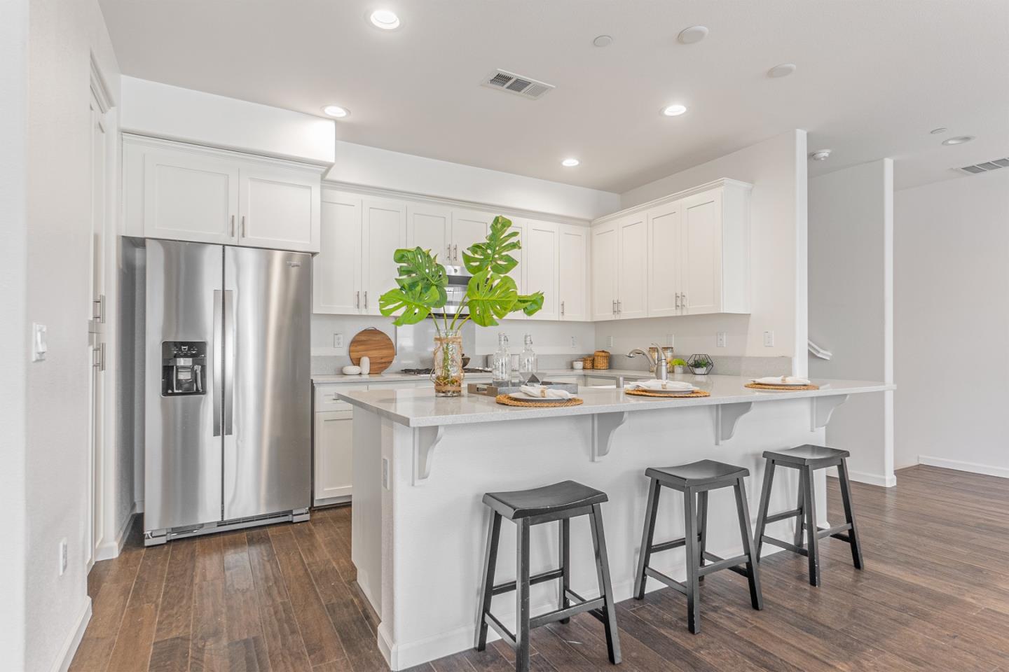 1926 Trento Loop Milpitas, CA 95035 - Photo 7 of 43 a kitchen with kitchen island granite countertop a refrigerator and a stove top oven