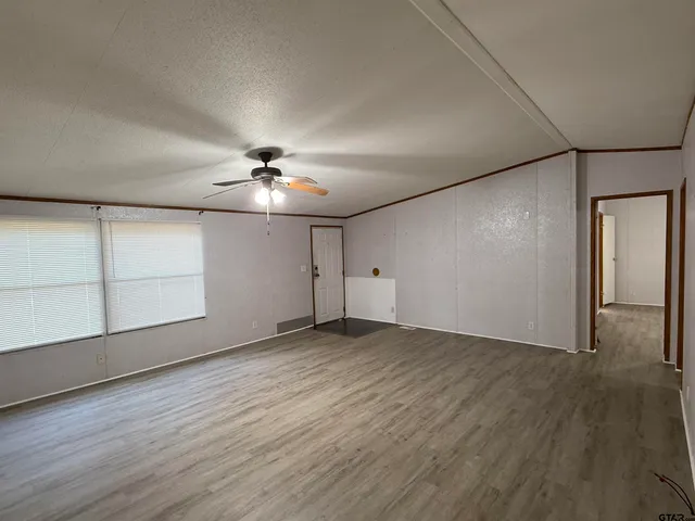 a view of an empty room with wooden floor
