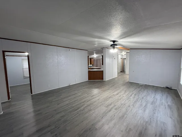 a view of empty room with wooden floor
