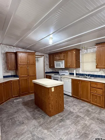 a large kitchen with stainless steel appliances granite countertop a stove and a sink