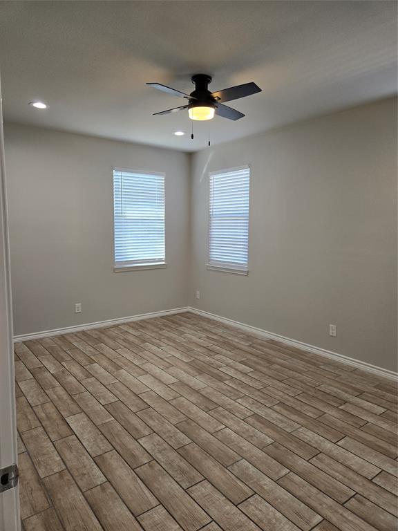 3704 Canyon Road Granbury, TX 76049 - Photo 11 of 30 an empty room with wooden floor chandelier fan and windows