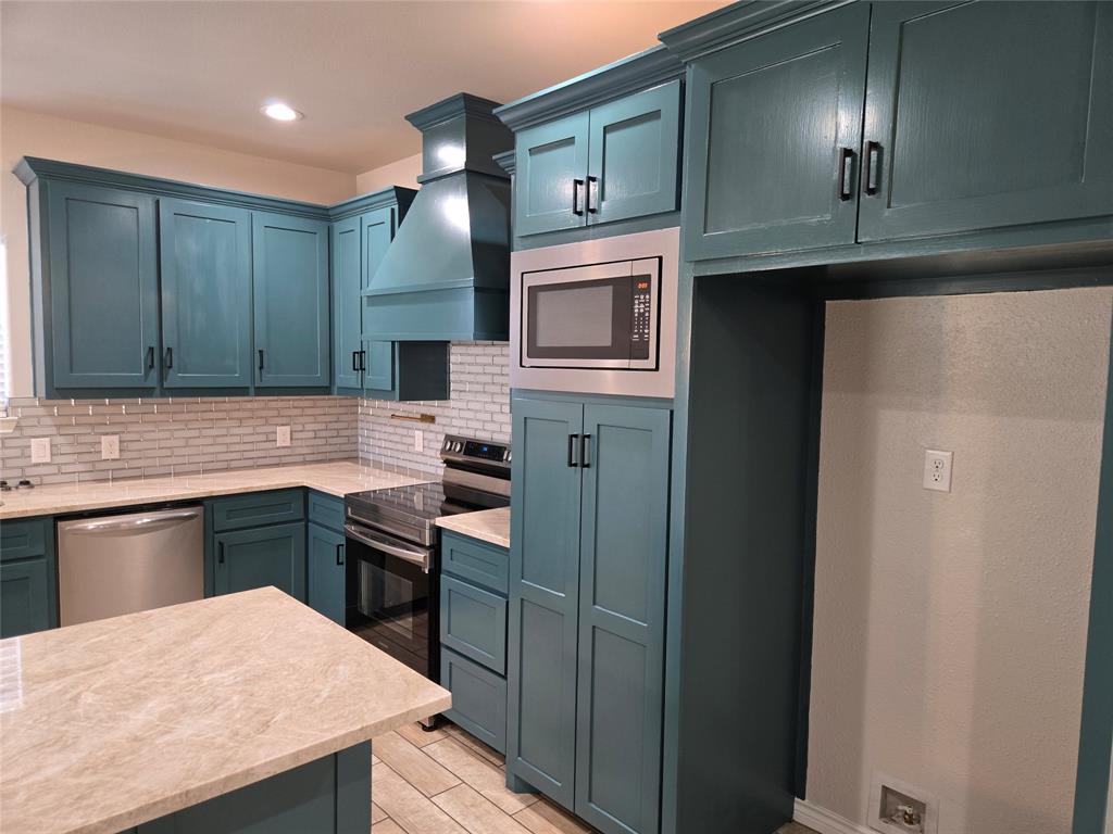 3704 Canyon Road Granbury, TX 76049 - Photo 8 of 30 a kitchen with cabinets and stainless steel appliances