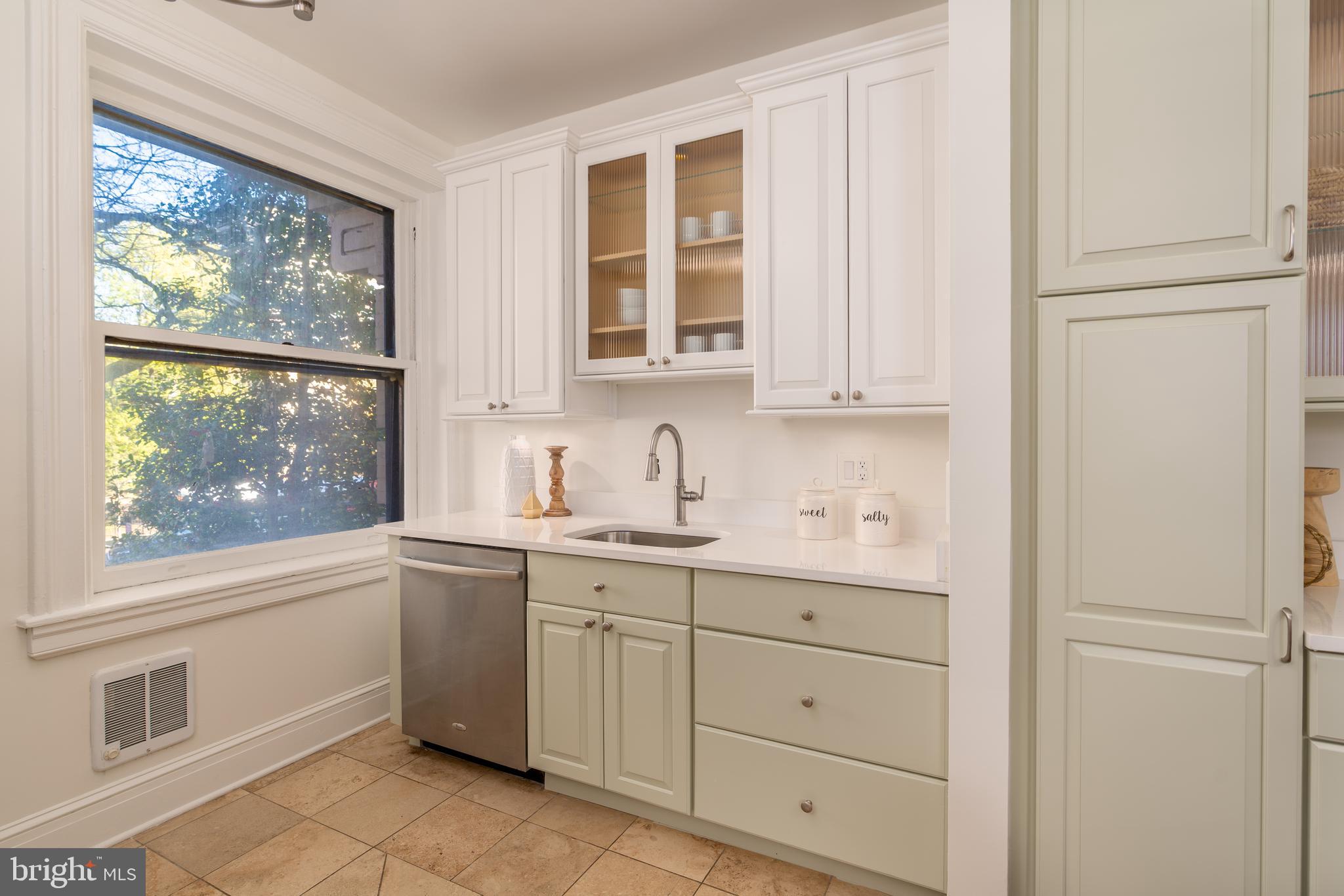 3060 16th Street Northwest, Unit 209 Washington, DC 20009 - Photo 12 of 33 a kitchen with white cabinets and window