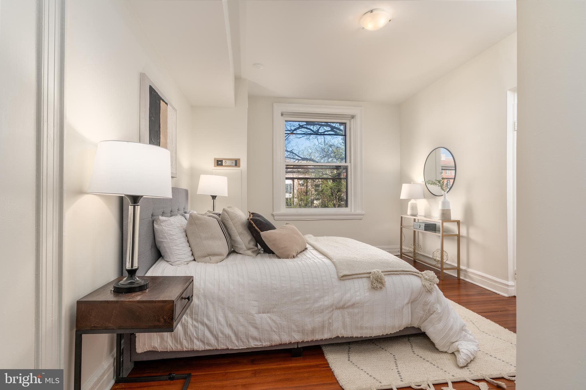 3060 16th Street Northwest, Unit 209 Washington, DC 20009 - Photo 16 of 33 a bedroom with a bed a table and painting