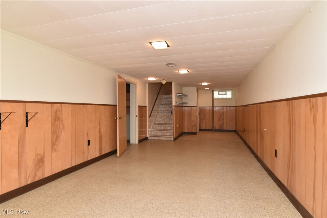 9421 David Road Cleveland, OH 44125 - Photo 28 of 36 Below grade area featuring a wainscoted wall, stairway, wood walls, and light floors