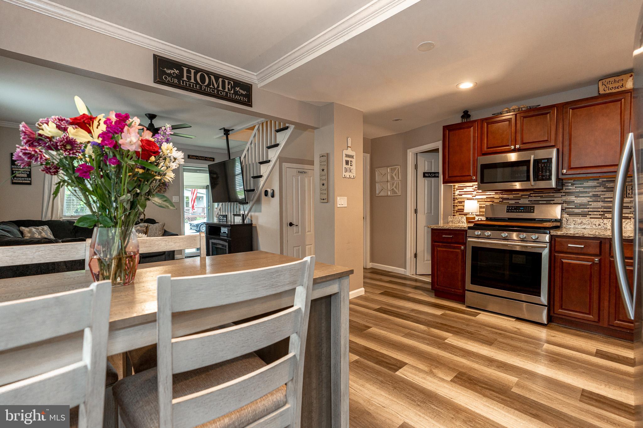 220 Pinewood Road Baltimore, MD 21222 - Photo 4 of 45 a kitchen with granite countertop kitchen island stainless steel appliances and flowers