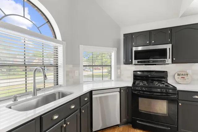 a kitchen with granite countertop a sink and a stove top oven