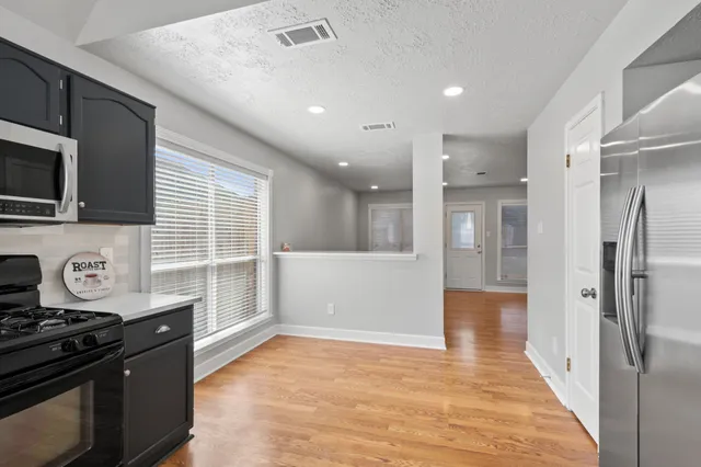 a view of a kitchen with a sink and a refrigerator